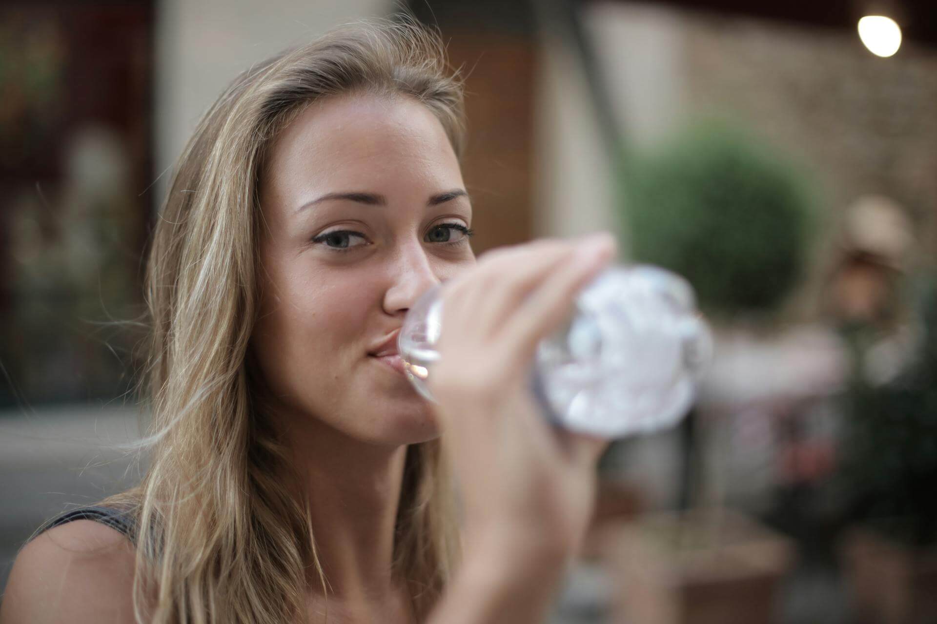 Dieses Foto zeigt eine junge Frau, die Wasser trinkt – eine gesunde Routine.